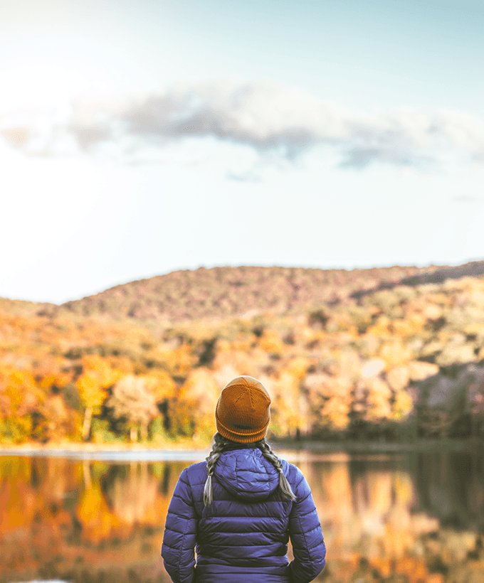 Person facing opposite direction overlooking lake